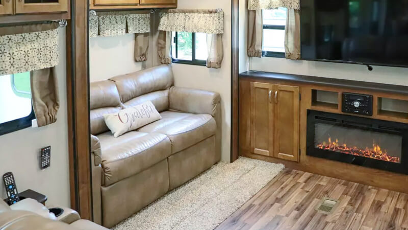 Interior view, tri-fold sofa, entertainment center and fireplace